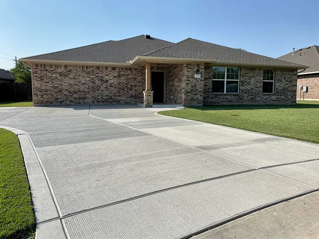 Newly poured concrete driveway at a home in Pearland, Texas with a broom finish